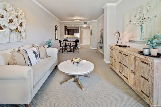 A modern living room with a cozy sofa, stylish coffee table, and adjoining dining area.