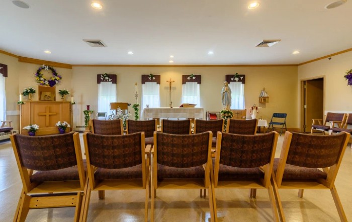 An interior view of a meeting room with arranged chairs facing forward.