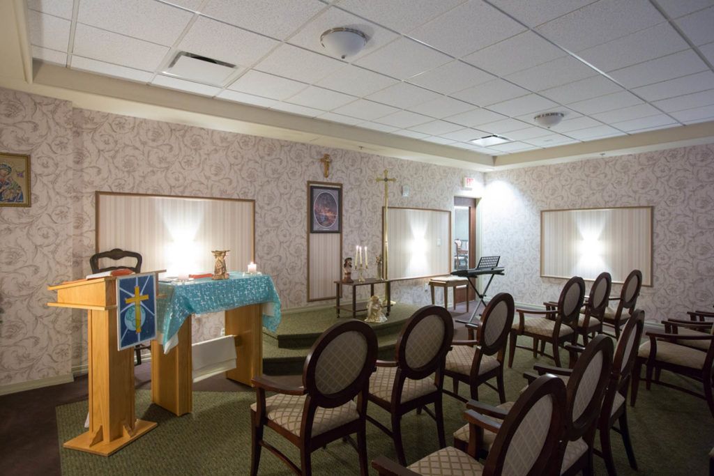 A small chapel with rows of chairs facing an altar in a peaceful setting.