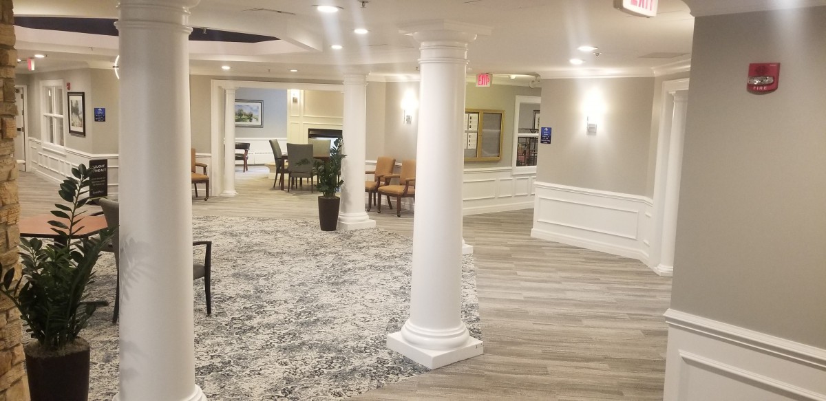 A modern lobby interior with white columns, comfortable seating, and elegant lighting.