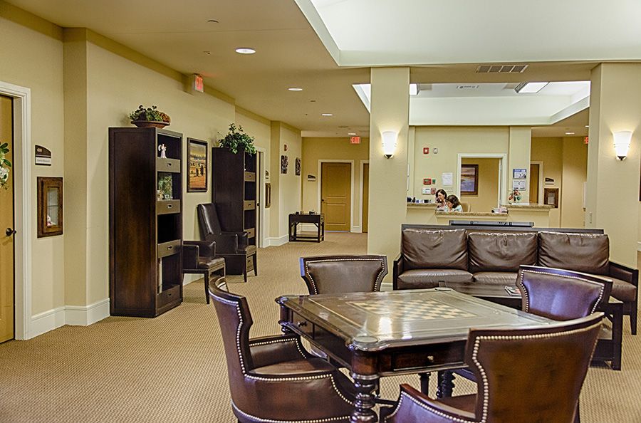 A warm and inviting lobby with comfortable seating, bookshelves, and a reception area.