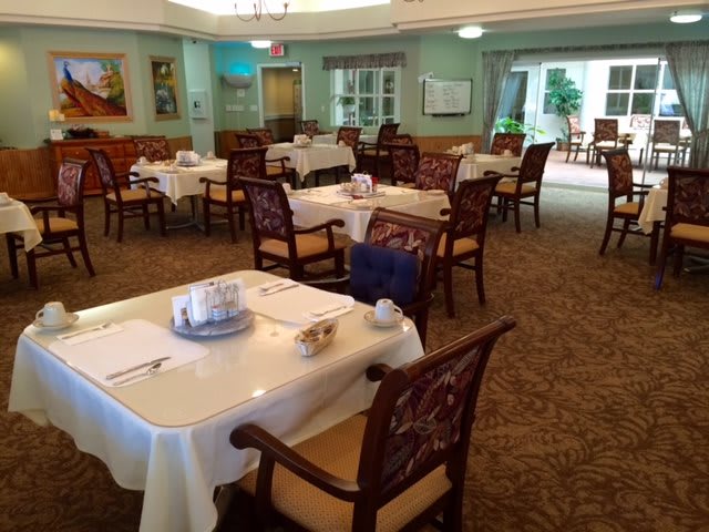 A well-appointed dining room with neatly arranged tables and chairs, ready for guests.
