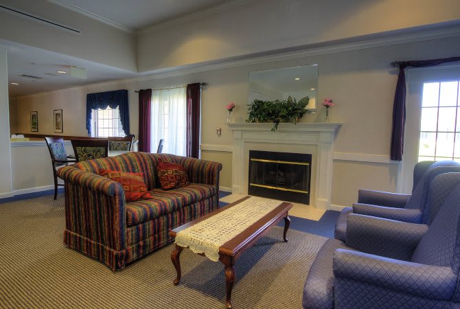 A cozy living room featuring a striped sofa, fireplace, and coffee table with elegant decor.