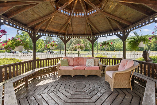 A cozy wooden gazebo featuring comfortable seating, perfect for enjoying the outdoors.