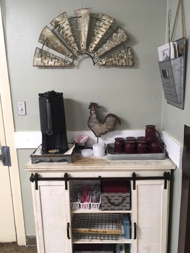 A cozy coffee station with country-themed decor, featuring a coffee maker, decorative chicken, and stylish storage.