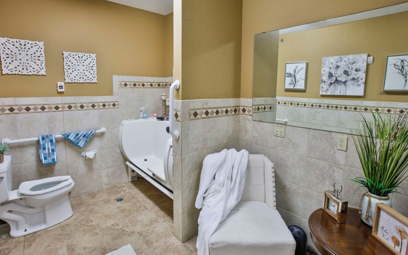 A modern bathroom featuring a bathtub, tiled walls, and a large mirror.