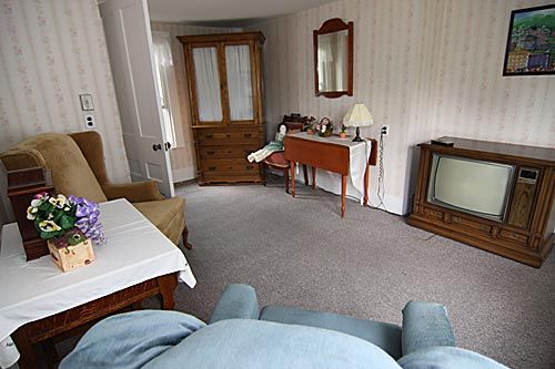 A cozy vintage living room with wooden furniture and an old television.