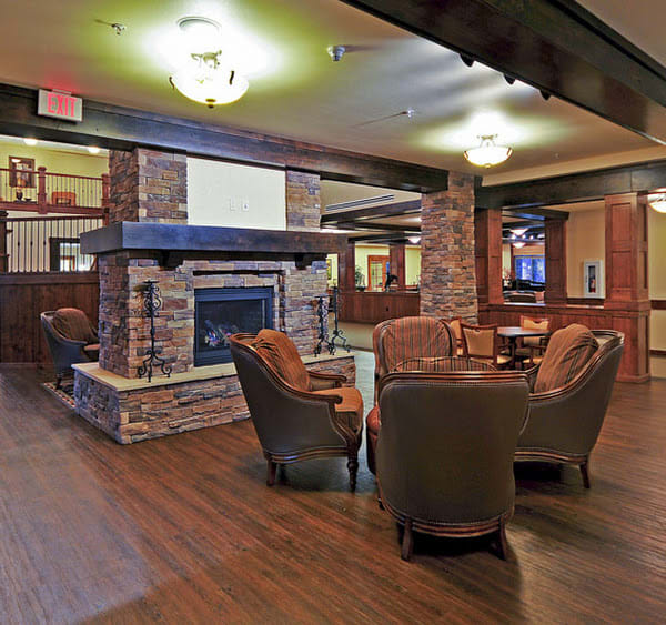 A cozy lounge with a central fireplace and comfortable seating.