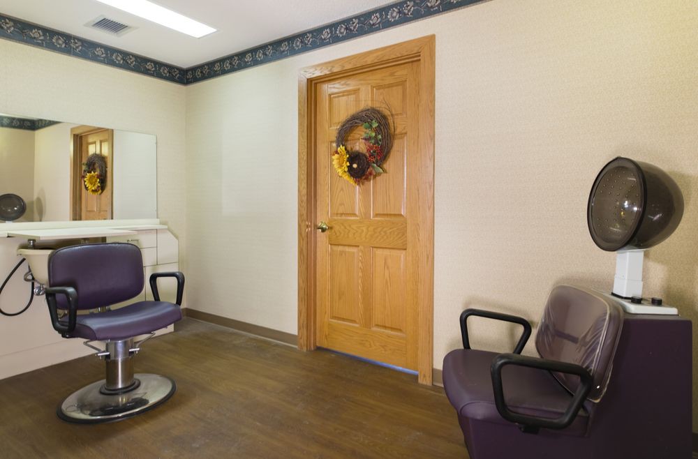 A cozy waiting room featuring two chairs and a decorated door.