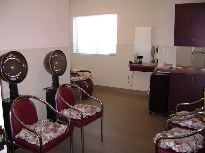 An interior view of a hair salon with styling chairs and a hair dryer.