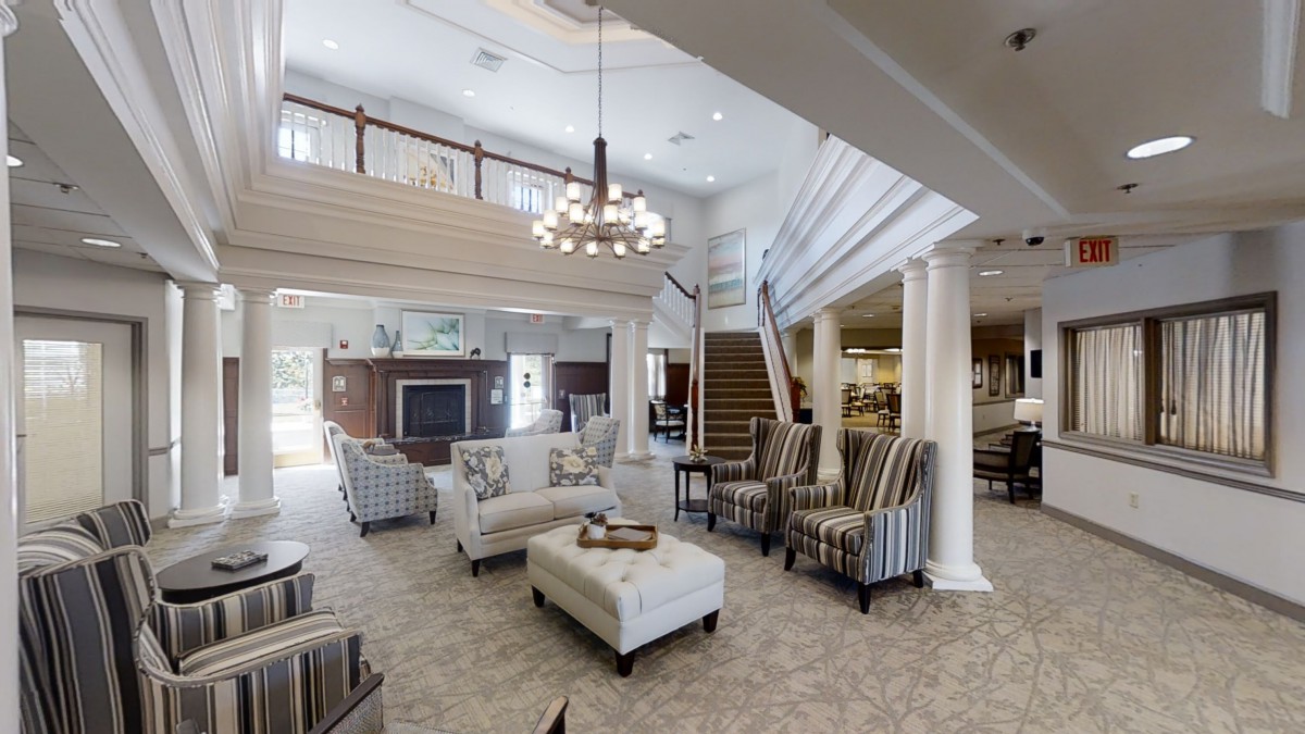 A spacious and elegant lobby with comfortable seating and a modern chandelier.