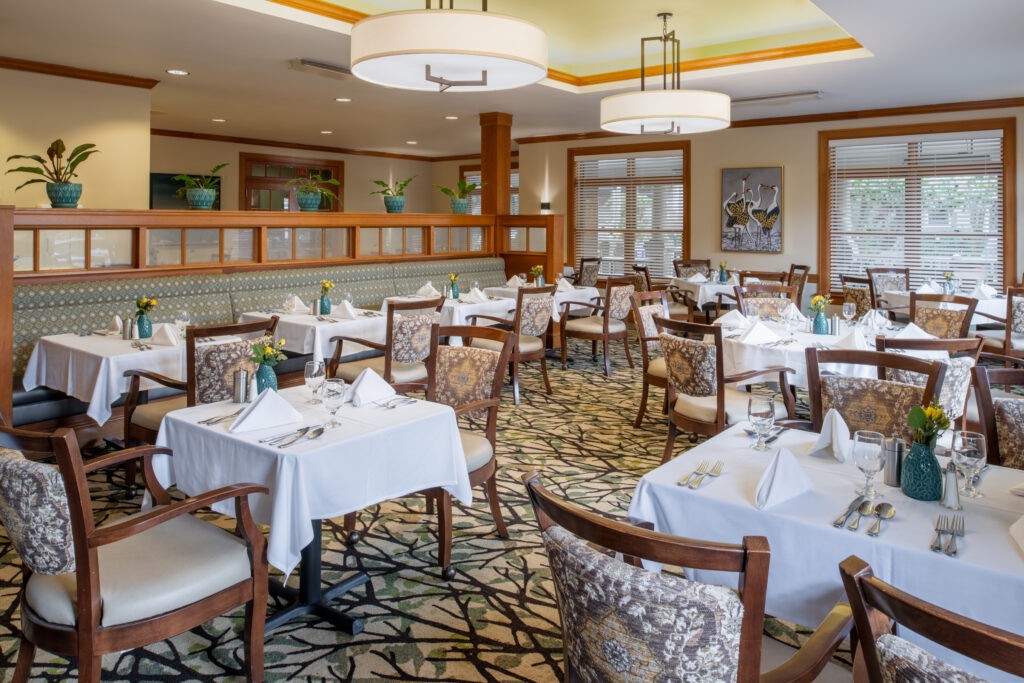 An elegant restaurant dining room with neatly arranged tables and chairs.