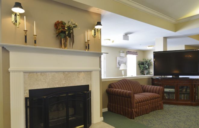 A cozy living room with a fireplace and a striped sofa, featuring elegant interior decor.
