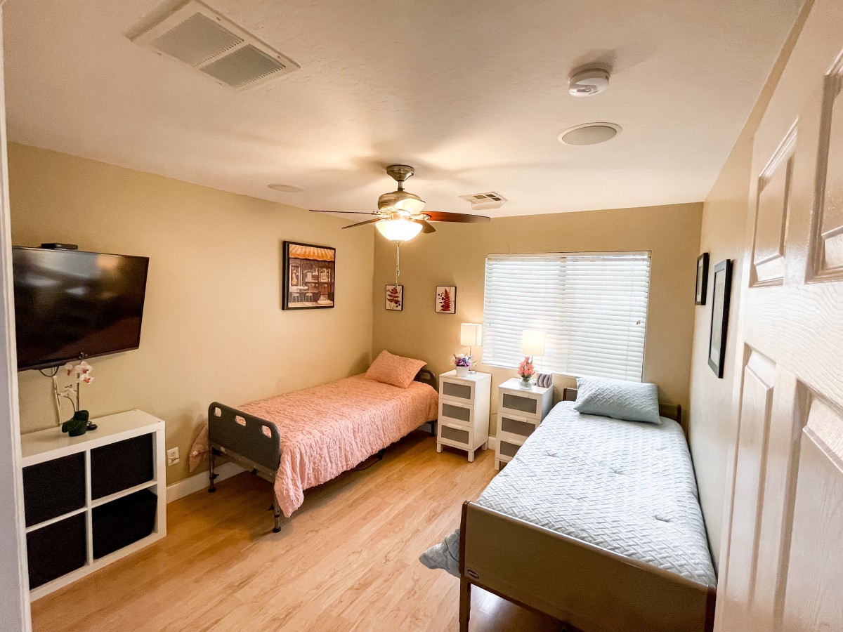 A tidy bedroom with two single beds, complete with nightstands and wall decorations.