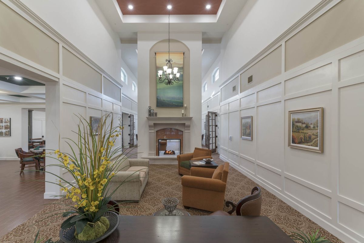 A spacious living room with high ceilings, featuring a fireplace and elegant decor.
