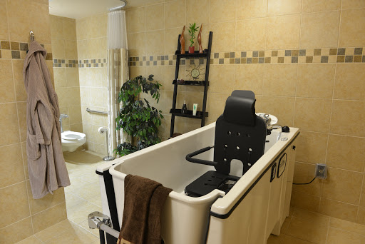 A serene bathroom featuring a comfortable bathtub, plants for decoration, and a simple yet elegant design.
