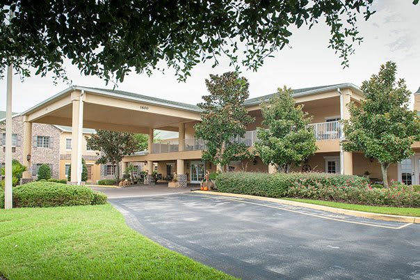 A hotel building with a covered entrance and surrounding greenery.