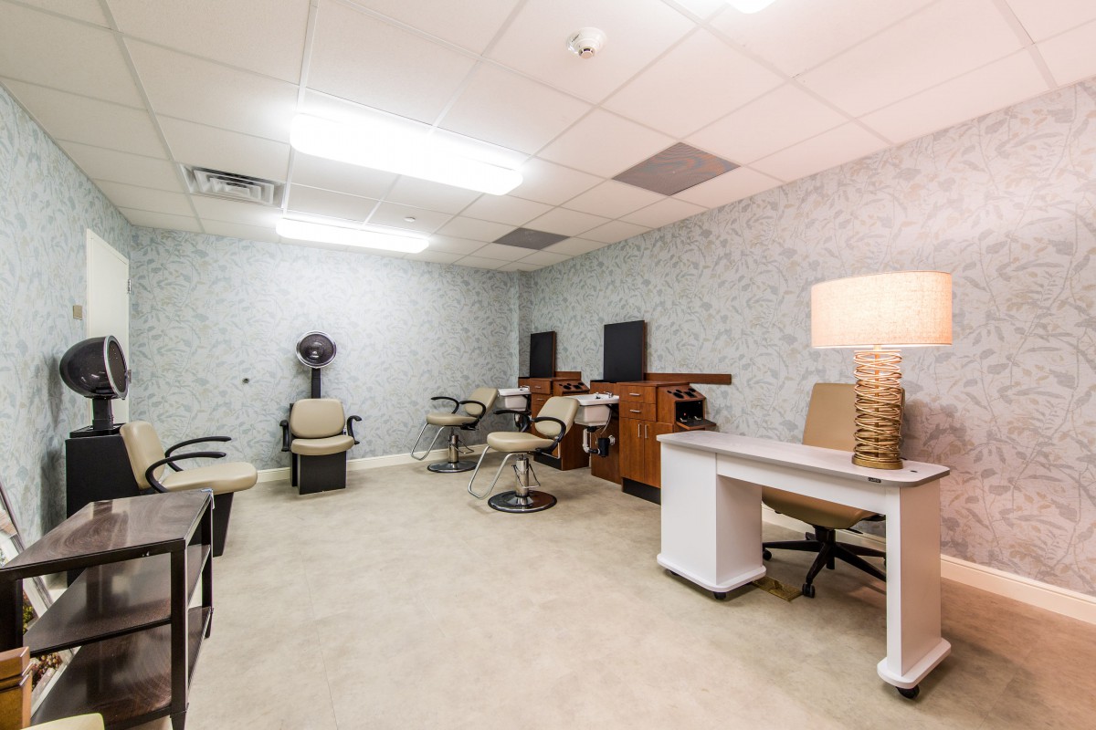 A modern hair salon interior featuring multiple workstations and styling chairs.
