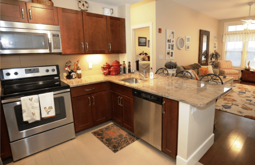 A modern kitchen interior featuring stainless steel appliances and wood cabinets.