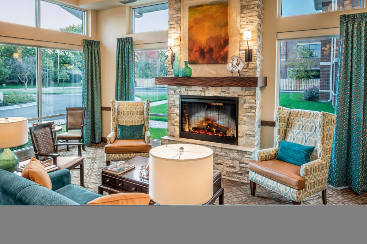 A cozy living room featuring a stone fireplace and comfortable seating arrangements.