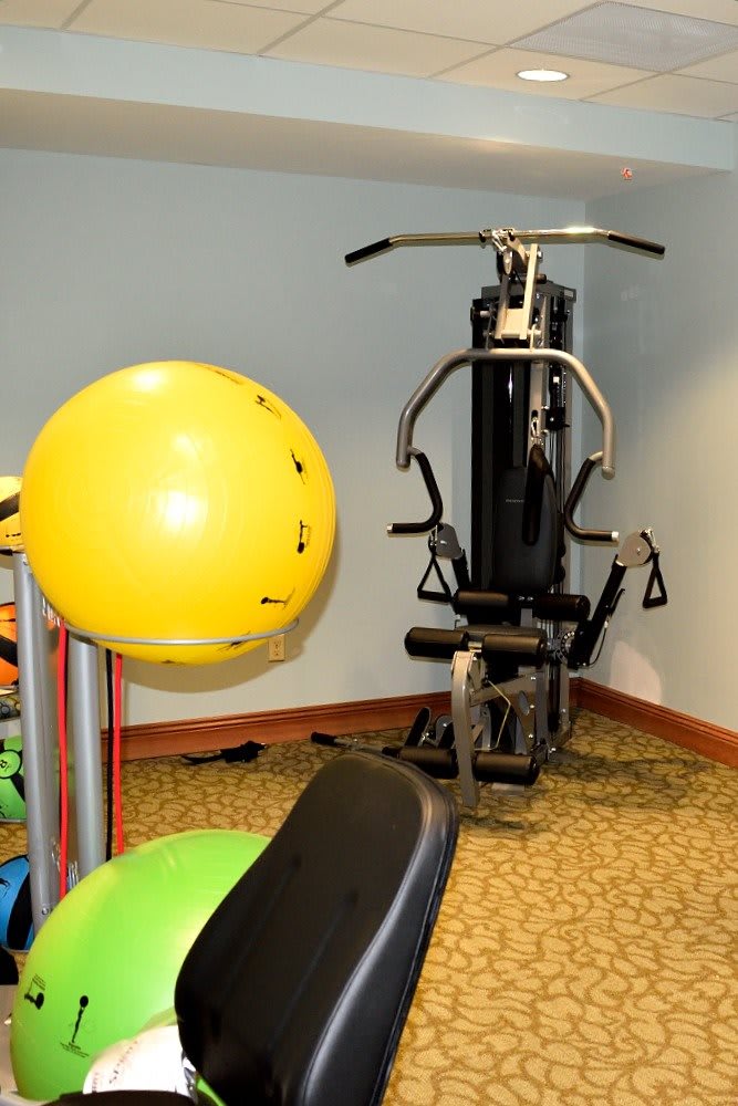 A gym room featuring a multi-gym machine and a yellow stability ball.
