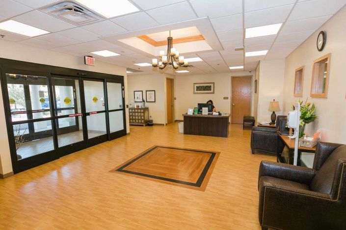 A spacious and well-lit lobby with a reception desk and comfortable seating.