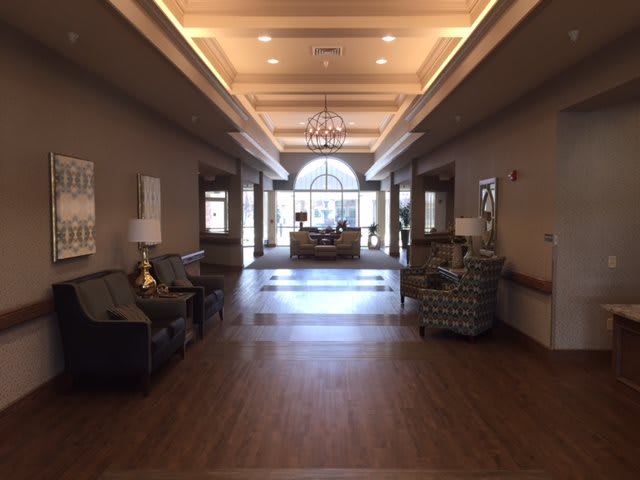 A spacious and elegantly decorated lobby with ample lighting and stylish furniture.