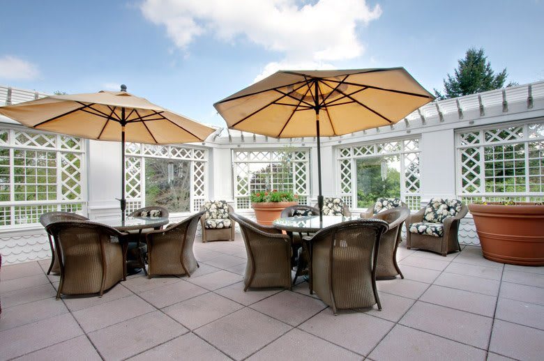 A stylish outdoor patio with tables and chairs under large umbrellas.