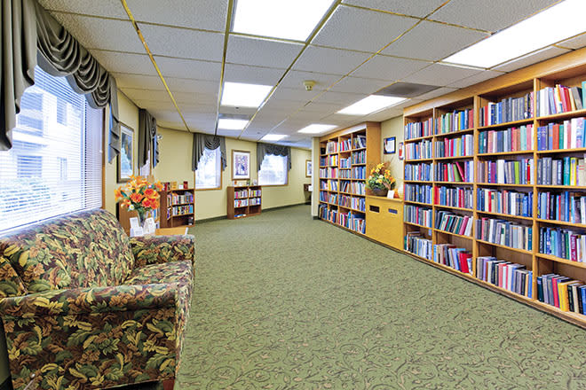 A cozy library with bookshelves lining the walls and comfortable seating.