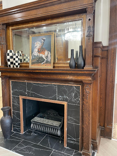 A beautifully designed fireplace with wooden detailing, featuring a framed artwork and decorative vases.