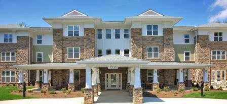 A three-story residential building with a brick facade and a welcoming entrance.