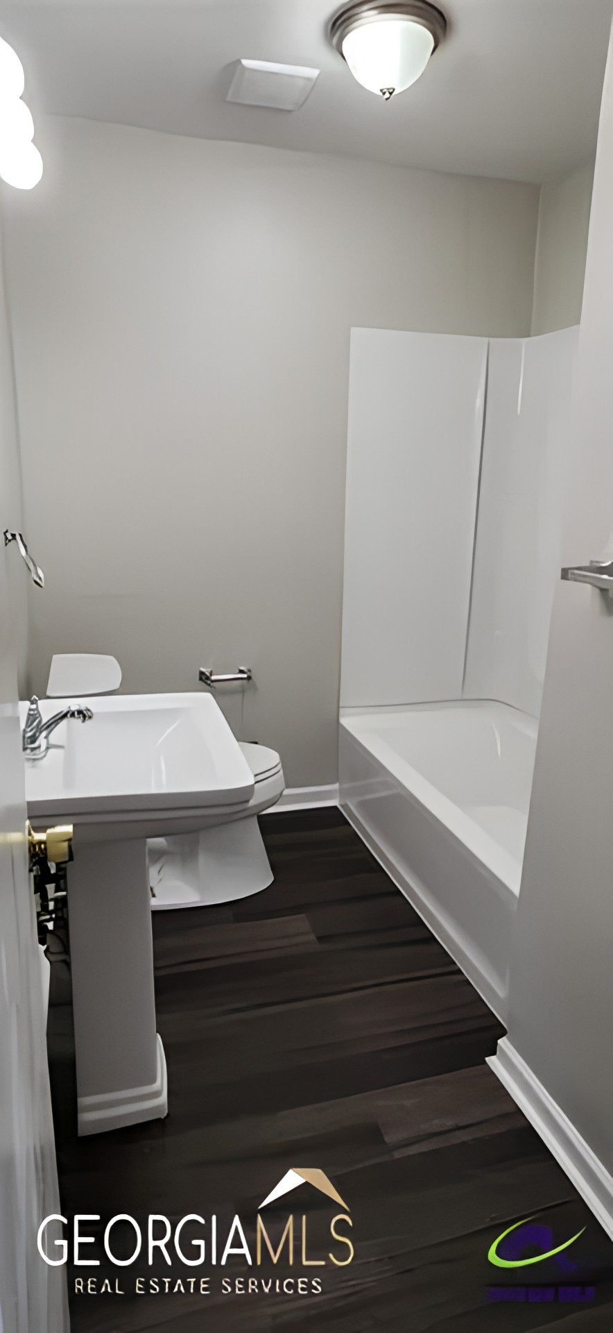 A modern bathroom with a sink, toilet, and bathtub.