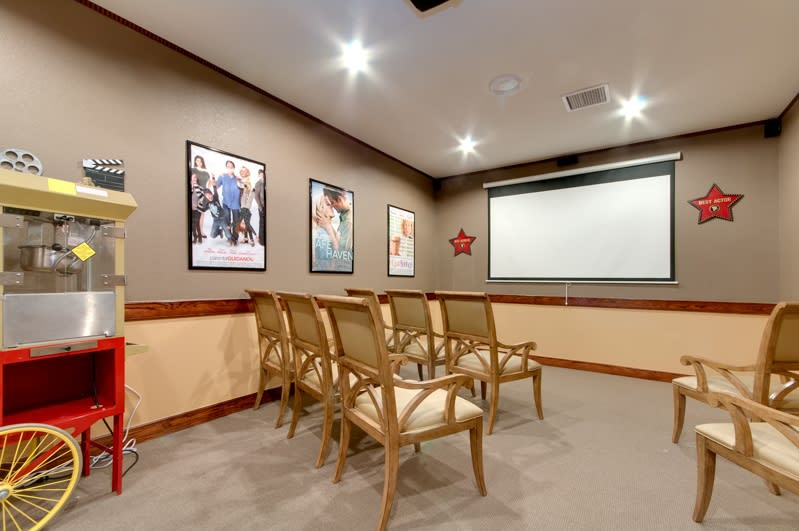 A small conference room with rows of chairs facing a projector screen.