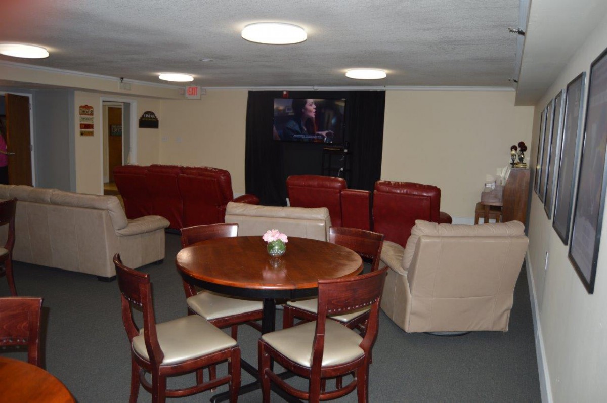 A cozy living room with sofas, a round table, and chairs.