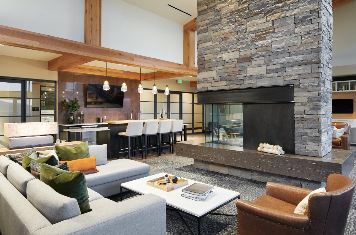 A modern living room with a stone fireplace and open floor plan.