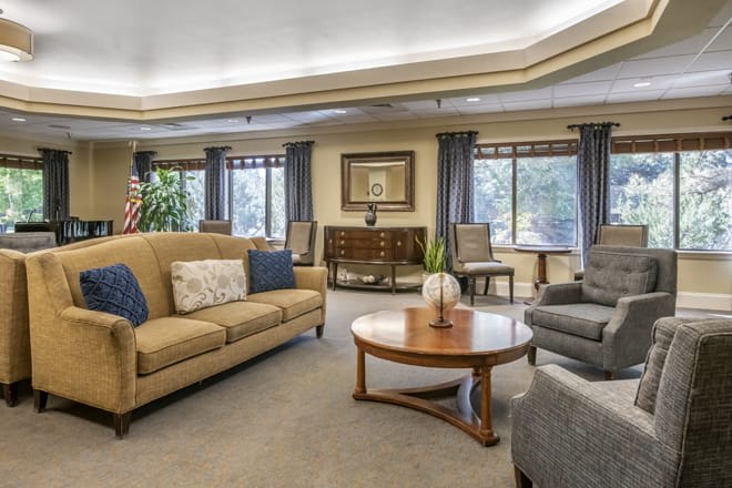 A cozy, well-furnished living room with sofas, an armchair, and a coffee table.