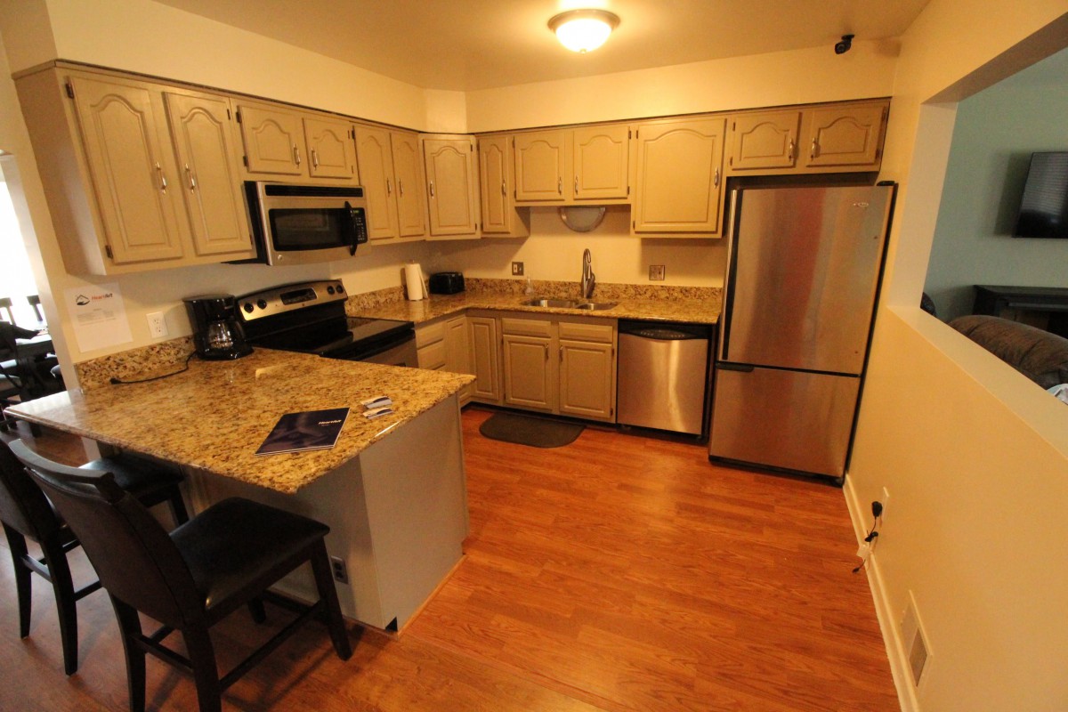 A modern kitchen with granite countertops and stainless steel appliances.