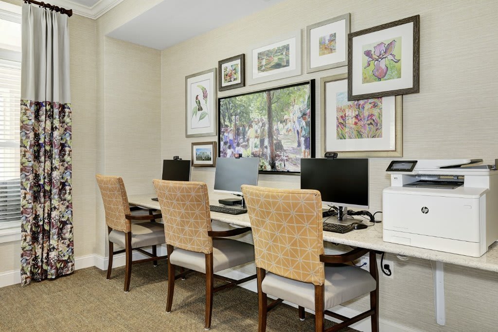 A well-organized office space with multiple workstations and decorative artwork on the walls.