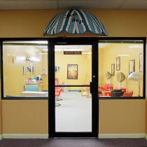 A cozy salon with vintage decor visible through a glass storefront entrance.
