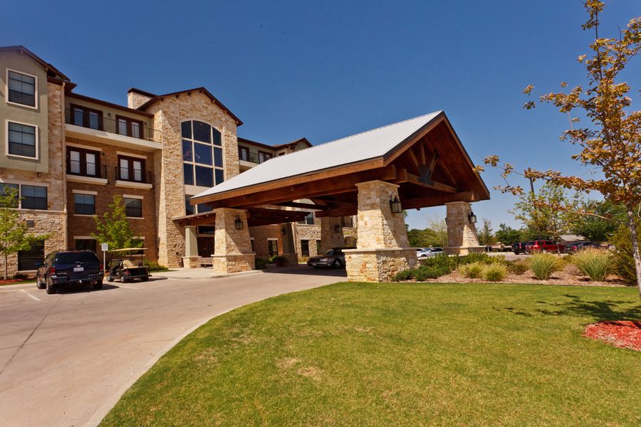 A scenic view of a hotel entrance with stone architecture and landscaped surroundings.