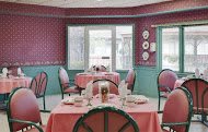 A vintage-style restaurant dining room with pink and green decor.