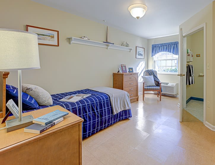 A cozy, well-lit bedroom with a single bed and nautical-themed decor.