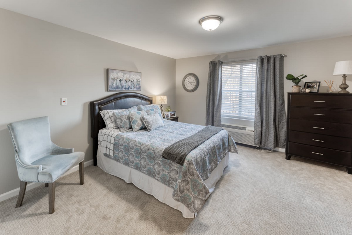 A cozy bedroom with a neatly made bed, soothing decor, and ample natural light.