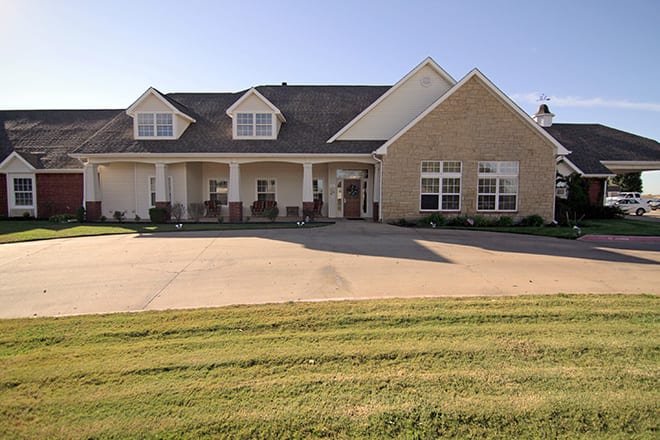 A suburban house with a spacious driveway and front porch.