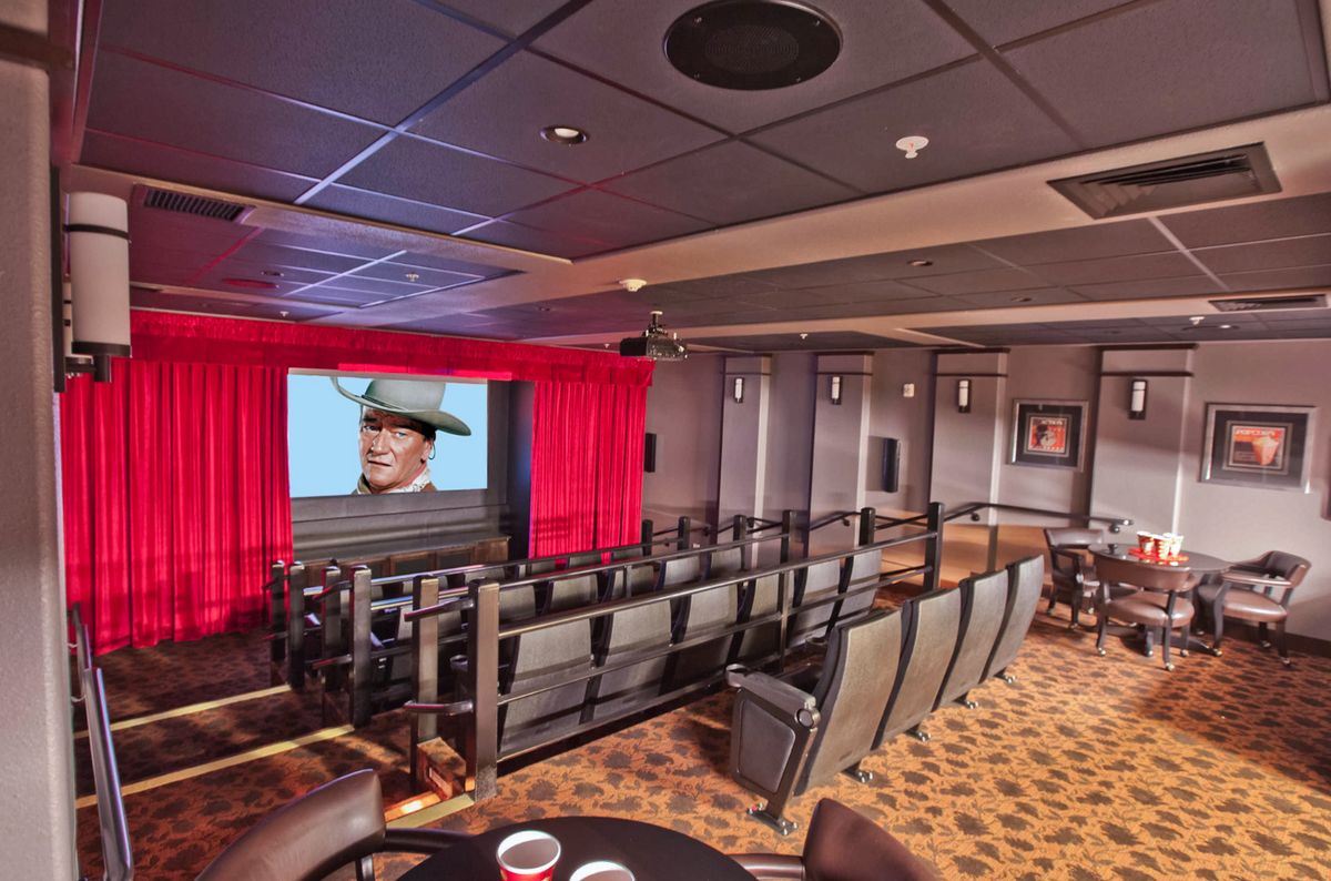 A cozy home theater with plush seating and a large screen.