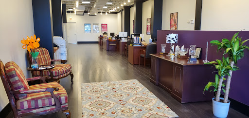 A modern office interior featuring multiple workstations and a decorative rug.