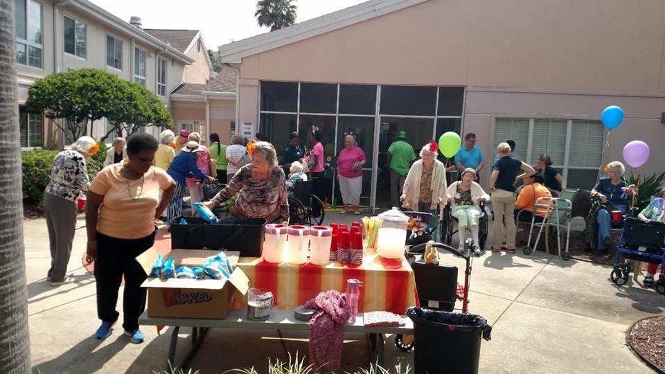 A community gathering with people enjoying snacks and drinks outdoors.
