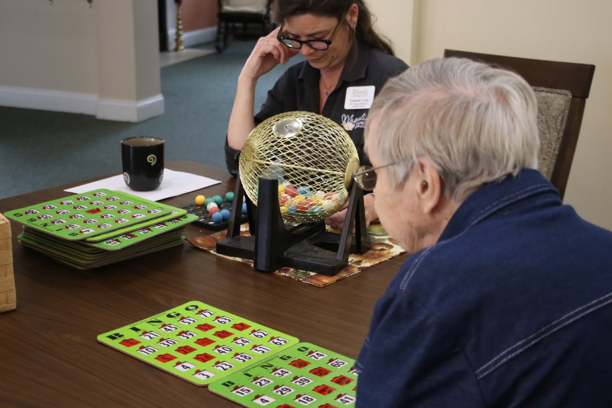 Elderly individuals enjoying a game of bingo indoors.