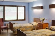 A cozy bedroom with twin beds and a large window.