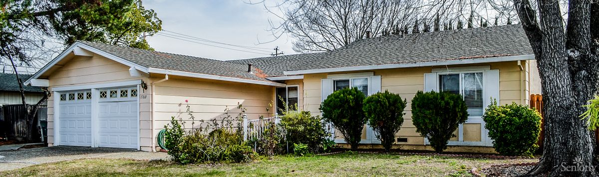 A suburban house with a well-maintained yard and shrubs.